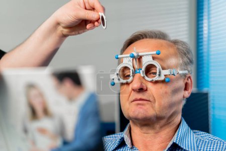 Téléchargez les photos : Close up Dans une clinique d'ophtalmologie, un médecin obèse choisit des lentilles adaptées à un patient - en image libre de droit