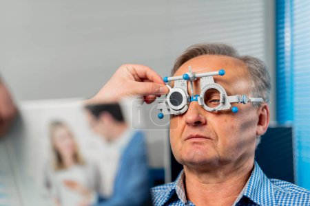 Téléchargez les photos : Close up Dans une clinique d'ophtalmologie, un médecin obèse choisit des lentilles adaptées à un patient - en image libre de droit