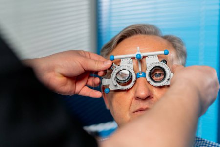 Photo for Close up In an ophthalmology clinic an obese doctor selects suitable lenses for a patient - Royalty Free Image