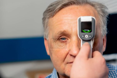 Photo for Close up in an ophthalmology clinic checking the pressure of the eyeball of elderly patient - Royalty Free Image