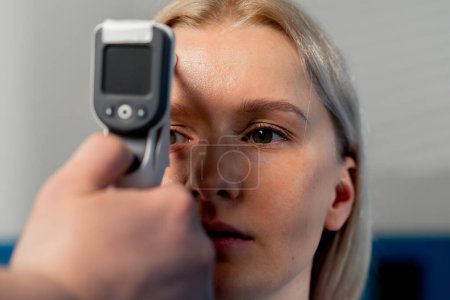 Téléchargez les photos : Gros plan dans une clinique d'ophtalmologie une jeune fille vérifie la pression du globe oculaire - en image libre de droit