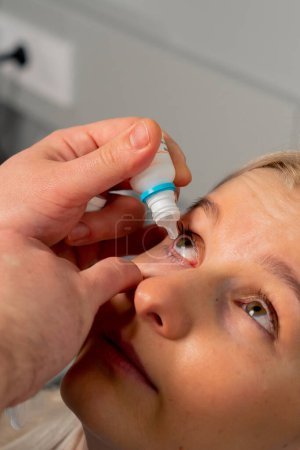 Téléchargez les photos : Gros plan dans une clinique d'ophtalmologie Gel gouttes sont mis dans un oeil de fille - en image libre de droit
