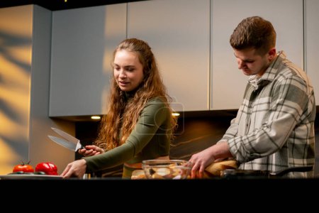 Téléchargez les photos : Jeune couple amoureux dans belle cuisine préparer le dîner ensemble heureux relation - en image libre de droit