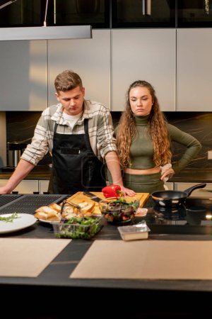 junges verliebtes Paar in schöner Küche kocht gemeinsam Konflikt negative Stimmung Streit