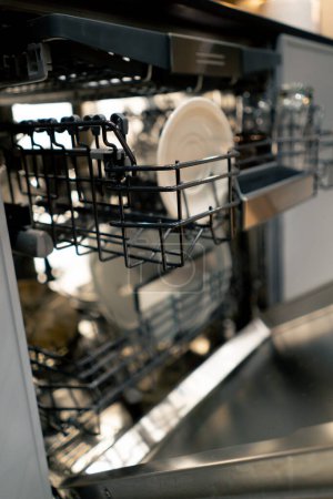 Foto de Close-up of a professional dishwasher with washed dishes device for home cleanliness and order - Imagen libre de derechos