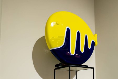 Téléchargez les photos : Close up ambiance chaleureuse d'un appartement design avec une sculpture d'un poisson bleu et jaune sur un stand - en image libre de droit