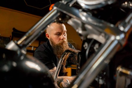 Foto de Cerrar En un taller de reparación de motocicletas un mecánico saca un filtro para reemplazarlo con uno nuevo - Imagen libre de derechos