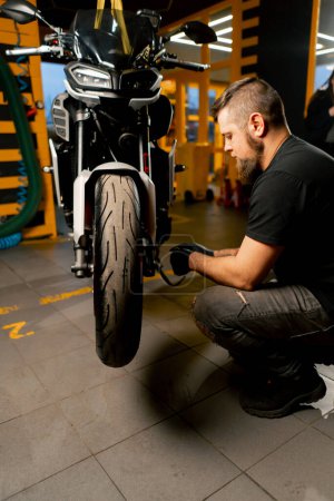 In einer Motorradwerkstatt repariert ein Federungssystem für ein Motorrad das Vorderrad