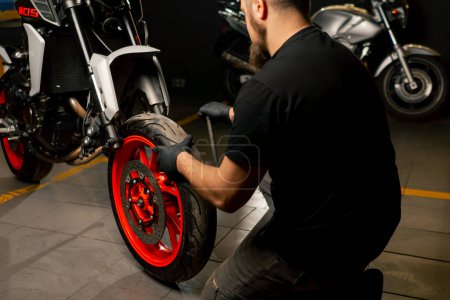 Dans un atelier de réparation de moto, un système de suspension pour une moto répare la roue avant