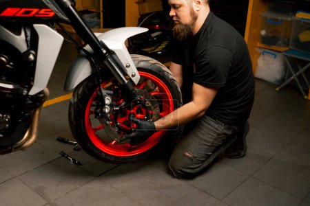 Dans un atelier de réparation de moto, un système de suspension de moto remplace une roue
