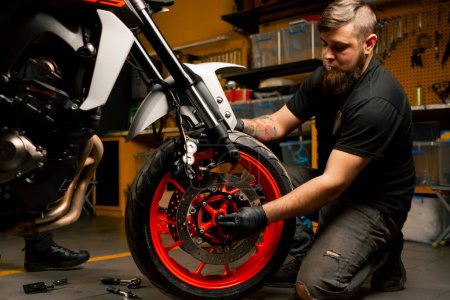 Dans un atelier de réparation de moto, un système de suspension de moto remplace une roue
