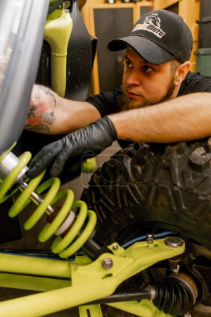Dans un atelier de réparation de moto, le mécanicien vérifie les freins d'un VTT extrême