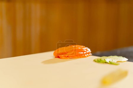 Foto de Primer plano en un restaurante japonés rebanado de pescado y aguacate en una pizarra blanca para un plato - Imagen libre de derechos