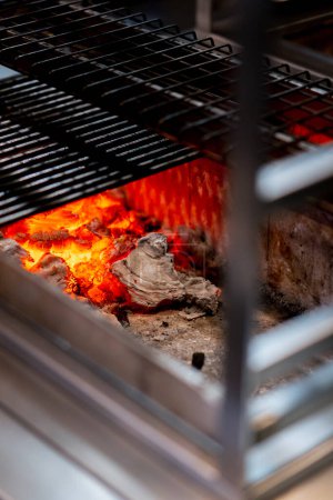 Téléchargez les photos : Close-up dans un restaurant japonais grill de table compact pour la cuisson des aliments charbons à haute température - en image libre de droit