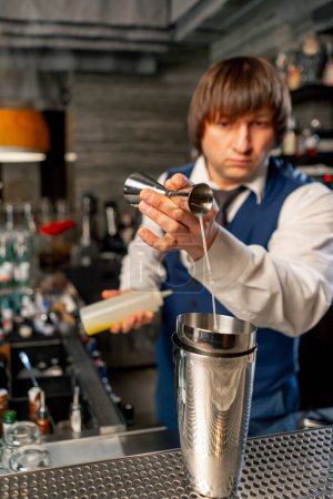Foto de En un restaurante japonés en el mostrador del bar el barman prepara un cóctel exótico - Imagen libre de derechos