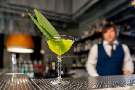 Téléchargez les photos : Dans un restaurant japonais il y a un cocktail vert exotique prêt à l'emploi sur le comptoir du bar - en image libre de droit
