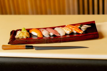 Téléchargez les photos : Close-up dans un restaurant japonais un ensemble prêt à l'emploi avec des sushis chers sur une longue assiette - en image libre de droit