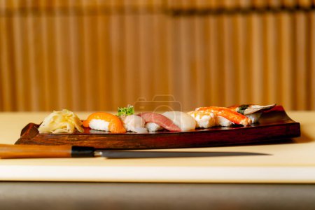 Téléchargez les photos : Close-up dans un restaurant japonais un ensemble prêt à l'emploi avec des sushis chers sur une longue assiette - en image libre de droit
