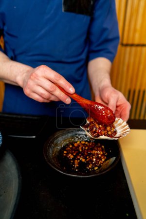 Foto de Primer plano en un restaurante japonés un chef en azul prepara un plato caro de mariscos - Imagen libre de derechos