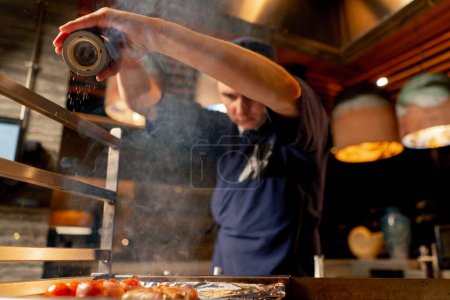 Foto de En el restaurante japonés el chef sales a la parrilla fritas varias verduras como guarnición para el pescado - Imagen libre de derechos