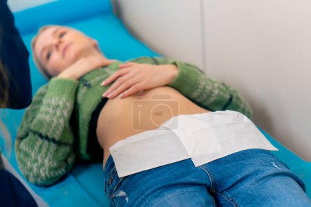 Téléchargez les photos : Gros plan dans une clinique gynécologique un jeune patient se couche sur un canapé pour une échographie - en image libre de droit