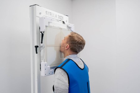 Foto de En una clínica privada en una sala de rayos X blanca paciente se prepara para un procedimiento - Imagen libre de derechos