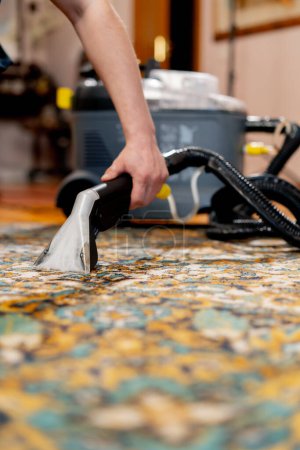 Téléchargez les photos : Fermer nettoyage professionnel de l'appartement le nettoyeur lave et aspire le tapis de la saleté - en image libre de droit