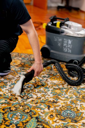 Foto de La limpieza profesional del apartamento el limpiador lava y aspira la alfombra de la suciedad - Imagen libre de derechos