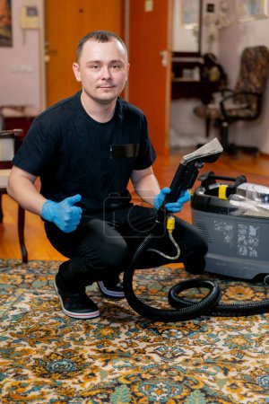 Foto de Limpieza profesional en un limpiador de apartamentos con una aspiradora de lavado muestra un super dedo - Imagen libre de derechos
