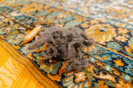 Téléchargez les photos : Fermer nettoyage professionnel de l'appartement il y a un grattoir de laine et une bobine de laine sur le tapis une surface propre - en image libre de droit
