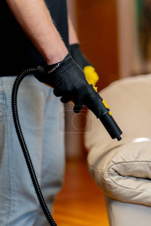 Photo for Close up a professional cleaning of the apartment cleaner steaming the skin on the sofa cleaning furniture - Royalty Free Image