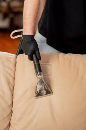 Téléchargez les photos : Close up nettoyage professionnel de nettoyage d'appartement aspirateur avec canapé textile détergent - en image libre de droit