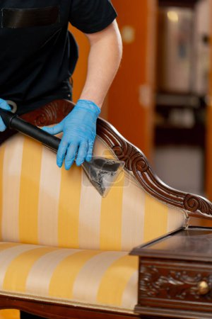 Foto de Limpieza profesional de un apartamento un limpiador moja la consola antes de lavar - Imagen libre de derechos
