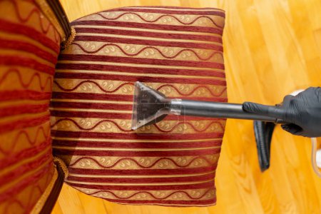 Foto de Top shot limpieza profesional de la aspiradora apartamento limpiador con detergente textil silla roja - Imagen libre de derechos