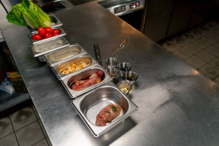 Téléchargez les photos : Dans une cuisine professionnelle, tous les ingrédients d'une salade grecque reposent sur une table en fer - en image libre de droit