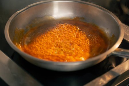 Foto de El primer plano en la salsa profesional de cocina para las alas en la sartén - Imagen libre de derechos