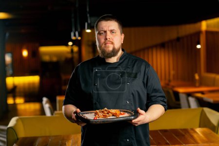 Téléchargez les photos : Dans un chef de restaurant dans un stand veste noire avec des ailes de poulet préparées - en image libre de droit