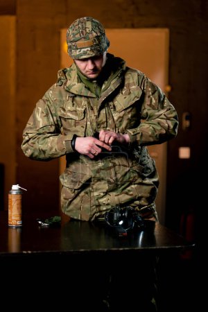 Foto de En un campo de tiro profesional un militar con munición recarga una pistola - Imagen libre de derechos