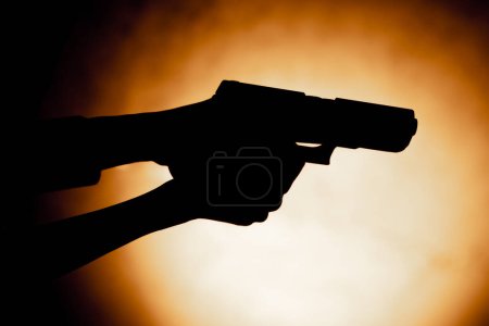 Photo for Close-up of female hands holding a pistol contrast light readiness to shoot correct position of hands - Royalty Free Image