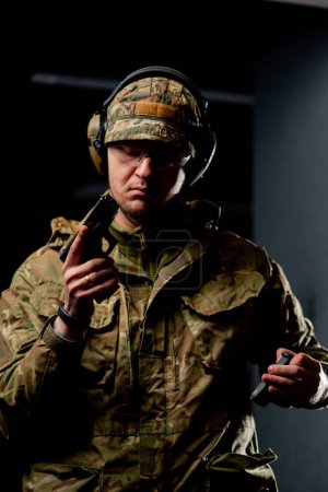 Foto de Primer plano en un entrenador militar de tiro profesional en puestos de munición con una pistola - Imagen libre de derechos