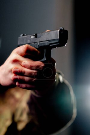 Foto de Cerca de un campo de tiro profesional un entrenador militar sostiene una pistola apuntando hacia abajo - Imagen libre de derechos