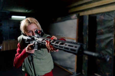 At a professional shooting range a girl takes aim before firing from a NATO rifle