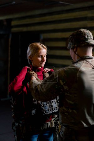 At a professional shooting range a military trainer puts tactical ammunition on a cheap girl