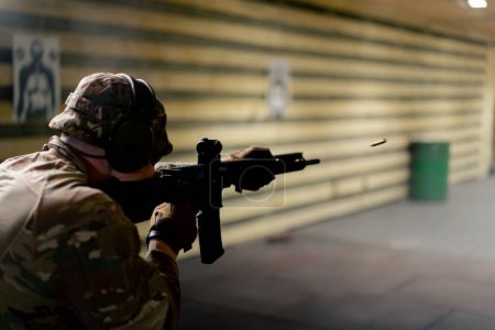 Foto de En un campo de tiro profesional un militar con munición hace un disparo con un rifle de la OTAN - Imagen libre de derechos