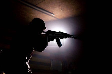 Foto de Una estrategia táctica militar que apunta a la silueta de contraluz de la luz trasera del rifle OTAN - Imagen libre de derechos