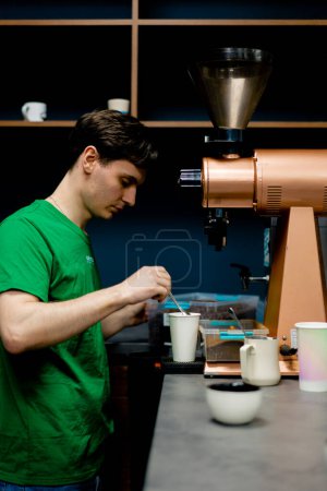 Téléchargez les photos : Un testeur de café dans une usine de café se prépare à tester le café fraîchement moulu de l'usine de torréfaction - en image libre de droit