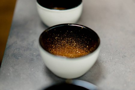 Foto de Primer plano en una fábrica de café hay tazones blancos con café recién molido - Imagen libre de derechos