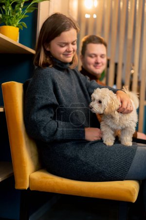Téléchargez les photos : Le chien dans les bras de son propriétaire il est heureux d'être le prochain son premier voyage au café de chien - en image libre de droit
