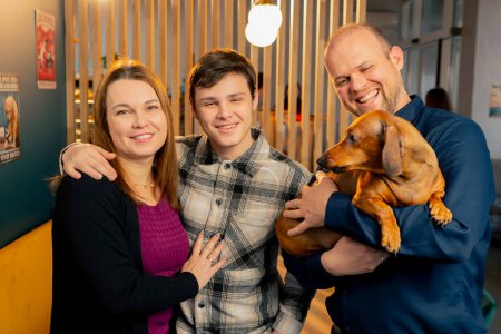 foto familiar con un pequeño dachshund en sus brazos en un café un momento feliz para toda la familia