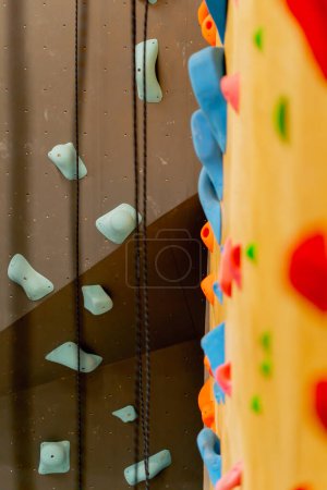 Téléchargez les photos : Fermer un professionnel beau nouveau grimpeur pour l'entraînement et l'entraînement de différentes couleurs de mur - en image libre de droit